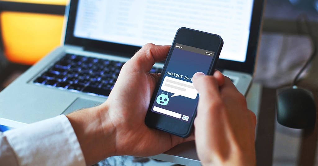 A man holding a mobile phone looking at a chat interface.